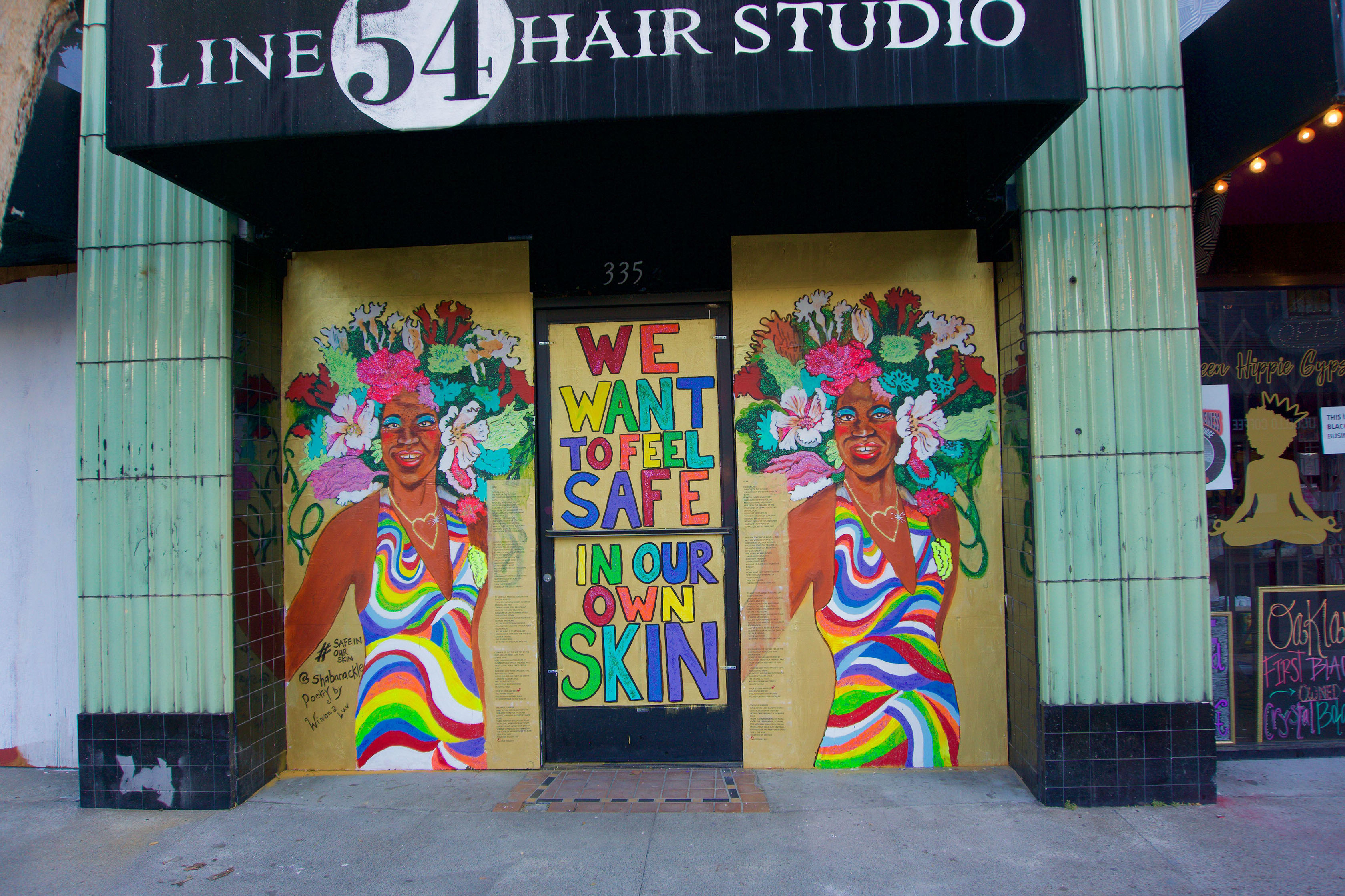 Front side of hair studio with colorful graffiti on black queens