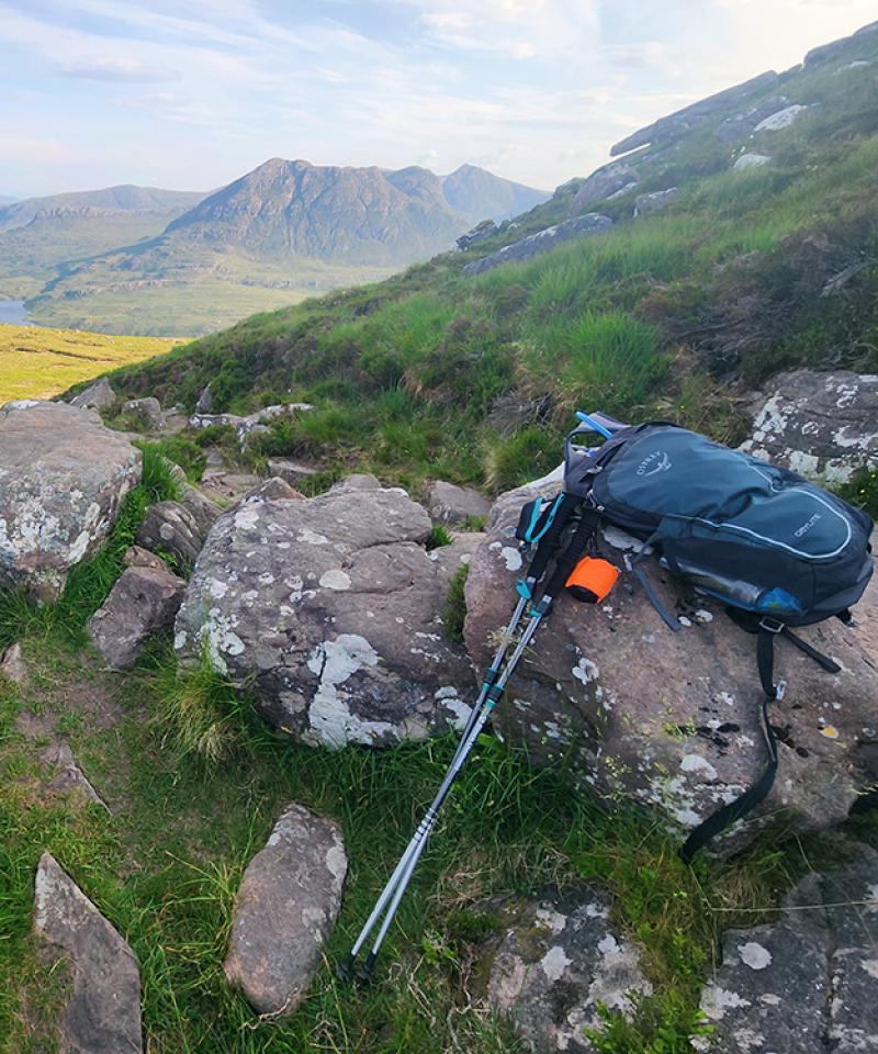 Scotland landscape with hiking sticks and backback in foreground